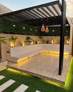 an outdoor living area with wooden flooring and white benches under a pergolated roof