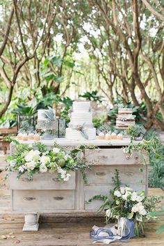 the dessert table is decorated with greenery and candles