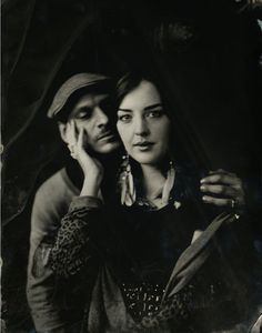 an old black and white photo of a man holding a woman's head with both hands