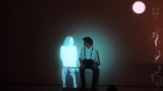 a man sitting on top of a white bench in front of a light colored wall