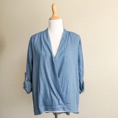 Boutique Wrap Front Blue Chambray Top By Hayden Los Angeles. Crossover Wrap Front With Tacking At Bust High Low Hemline Rolled Sleeves With Button Tab. Loose, Oversized Fit Cotton Gauze Chambray Light Denim Fabric And Buttons On Sleeve Tab New Boutique Item With Tags 100% Cotton Hand Wash Size Large Play It Cool In The Blue Chambray Wrap Top From Hayden. Denim Blue V-neck Top, Denim Blue Tops For Layering, Light Wash V-neck Top For Day Out, Blue Denim Top For Summer Workwear, Summer Blue Denim Top For Work, Trendy Denim Blue V-neck Top, Denim Tops For Layering, Blue Denim V-neck Top, Chic Blue V-neck Denim Top