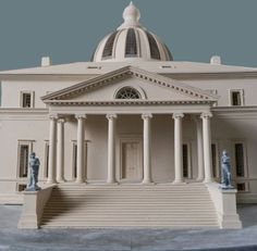 a model of a white building with statues on the front and stairs leading up to it