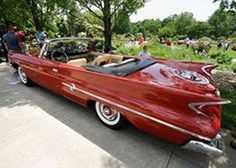 an old red convertible car parked on the street