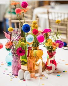 colorful flowers in vases on a table with confetti