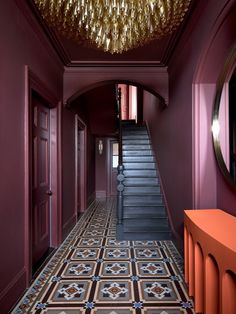 the hallway is decorated in purple and gold with a chandelier hanging from the ceiling