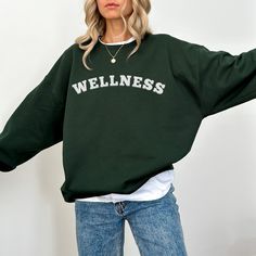 Check out our new trendy Wellness crewneck sweatshirt in dark chocolate, black, green forest and royal colors. The uplifting message on the front adds a positive touch to your everyday wardrobe, making it a great choice for anyone who values self-care and well-being. ~ Q U I C K * I N F O ~ ❣️ 50% cotton and 50% polyester for that cozy feel and warmth ❣️ Machine wash: cold (inside out); Dry normally ~ S I Z I N G ~  ❣️ This sweatshirt is not oversized! Size of 1-2 + sizes for an oversized look. ❣️ Sizing is Unisex. Size guide:  SIZE/ Width/ Length/ Sleeve length  S - W"20" L"27" SL"33" M - W"22" L"28" SL"34" L - W"24" L"29" SL"35" XL - W"26" L"30" SL"36" 2XL - W"28" L"31" SL"37" 3XL - W"30" L"32 SL"38" 4XL - W"32" L"33" SL"39" 5XL - W"34" L"34" SL"40"  ❣️ If you are unsure of which size to Trendy Green Sweats For Fall, Green Slogan Sweatshirt For Streetwear, Green Letter Print Crew Neck Sweater, Fall Hoodie With Text Print And Crew Neck, Oversized Green Letter Print Sweater, Green Crew Neck Sweater With Letter Print, Fall Slogan Crew Neck Hoodie, Fall Crew Neck Hoodie With Text Print, Oversized Green Sweater With Letter Print