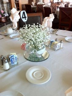 the table is set with flowers and napkins for guests to sit down at it