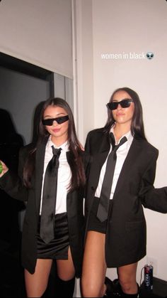 two women dressed in black and white posing for the camera