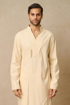 Ivory angrakha kurta with all over texture detailing. Paired with trouser.
Components: 2
Neckline: Mandarin
Sleeve Type: Full
Fabric: Katan Silk, Suiting
Color: Ivory
Other Details: 
Overlap panel
Model height: 5ft 9 inches, wearing size S
Occasion: Mehendi and Puja - Aza Fashions Trouser Men, Trouser For Men, Angrakha Kurta, Men Kurta, Tarun Tahiliani, Katan Silk, Color Ivory, Aza Fashion, Model Height