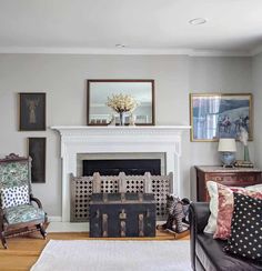 a living room filled with furniture and a fire place in front of a white fireplace