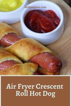 hot dogs wrapped in crescent rolls with mustard and ketchup on the side for dipping