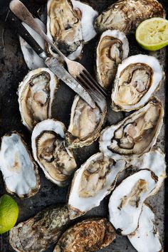 oysters on a grill with lemon wedges and knife