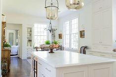 a large kitchen with white cabinets and an island in front of the countertop area