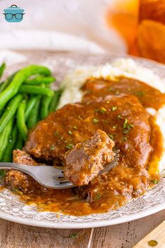 a close up of a plate of food with meat and gravy on it