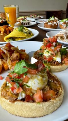 an assortment of food is displayed on a white platter with other plates in the background