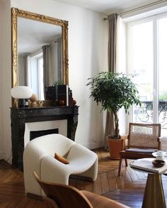 a living room filled with furniture and a large mirror