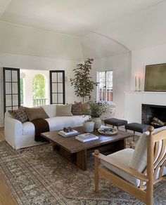 a living room filled with furniture and a large rug on the floor next to a fire place