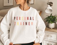 Your search for a personal trainer gift, birthday gift, Christmas gift or just something special is over. This Personal Trainer sweatshirt makes a great gift for girlfriends, wives, mothers, or daughters - anyone with an interest in getting fit. * Loose fit * 50% Cotton; 50% Polyester * Runs true to size Wash: For best results wash inside out on cold and line dry. SHIPPING DETAILS ♡ I will always do my best to ship all items as soon as possible. ♡ Standard processing time is 1-3 days to custom p Personalized White Sporty T-shirt, White Relaxed Fit Sweatshirt For Birthday, White Letter Print Sweatshirt For Gym, White Letter Print Sweatshirt For The Gym, White Letter Print Sweatshirt For Gift, White Letter Print Sweatshirt As Gift, White Personalized Sporty Top, Sporty Personalized White Top, Personalized Crew Neck Sports Top