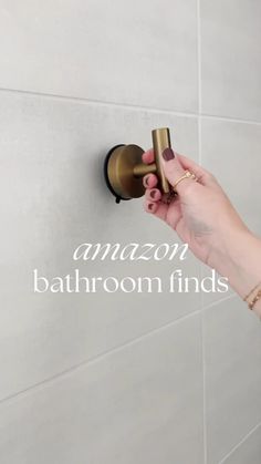 a person is holding an item in front of a wall with the words amazon bathroom finds on it