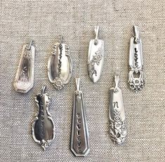 These sweet pendants are crafted from antique sterling silver plated spoon handles. They are about an inch in length and are hand letter stamped with the initial of your choice. They come with a sterling silver chain in your choice of length and style. You can also add a birthstone charm or add multiple charms to create a unique mother or grandmothers necklace. Each pattern is unique we can accommodate specific requests the best we can! Silverware Sculpture, Grandmothers Necklace, Silverware Repurposed, Vintage Spoon Jewelry, Vintage Silverware Jewelry, Spoon Earrings, Pea Pod Necklace, Spoon Handles, Silver Spoon Jewelry