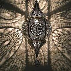 an intricate chandelier hanging from the ceiling in a room with shadows on it