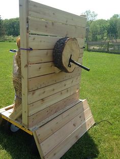 a large piece of wood is attached to a wooden structure in the middle of a grassy field