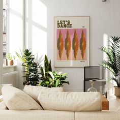 a living room filled with lots of plants next to a wall mounted art print on the wall