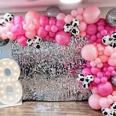 the balloon wall is decorated with pink, white and black balloons