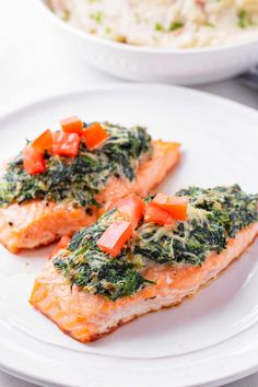 baked salmon fillets with spinach and tomatoes on a white plate text reads baked salmon florentine