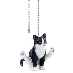 a black and white cat figurine hanging from a chain