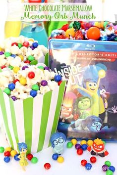 a close up of a box of popcorn and some candy on a table with other items