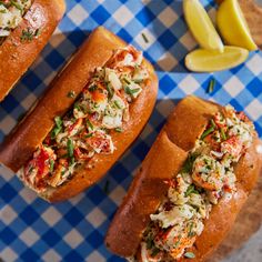 two hot dogs with cole slaw on a blue and white checkered tablecloth