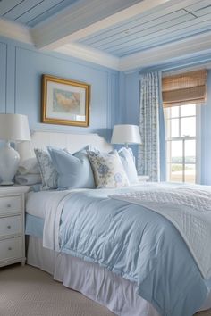 a bedroom with blue walls and white bedding