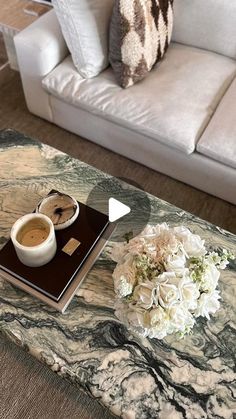 a marble coffee table with flowers on it