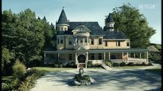 a large house with two towers on top of it's roof and an entrance way leading to the front door