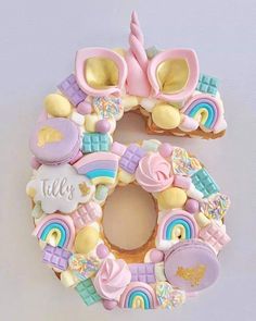 the number five made out of cookies is decorated with unicorns, rainbows and clouds