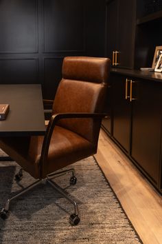 a brown leather office chair sitting in front of a desk