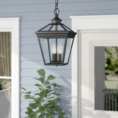 an outdoor light hanging from the side of a house