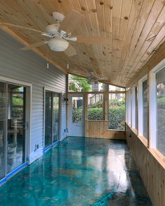 the inside of a house with blue flooring and ceiling fans on either side of the room