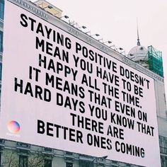 a large billboard on the side of a building that says staying positive doesn't mean you have to be happy all the time