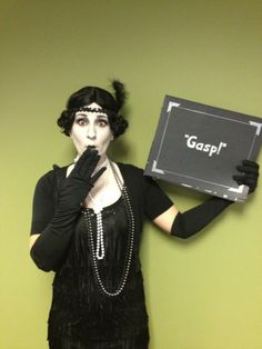 a woman dressed in black holding up a sign