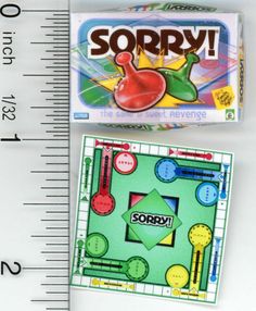 a close up of a box of candy next to a measuring ruler with the word sorry on it