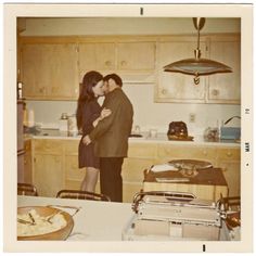 two people standing in a kitchen next to each other