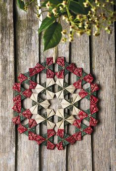 an ornament made out of wooden pieces with red and green ribbons on it