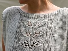 a woman wearing a gray sweater with flowers on it