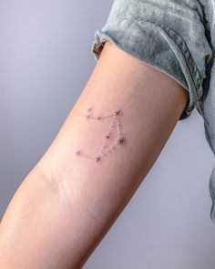 a woman's arm with a small star tattoo on the left side of her arm