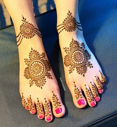 a woman's feet with henna tattoos on it