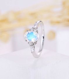 a white gold ring with an oval blue stone and diamonds