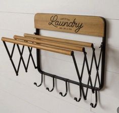 a wall mounted coat rack with three coats hanging from it's sides and two hooks on each side