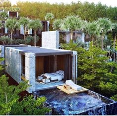 an aerial view of a house made out of concrete and surrounded by trees, in the middle of a wooded area